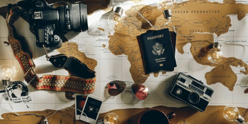 Planning a move abroad: world map, camera, and passport reflecting a dream to live in an English-speaking country